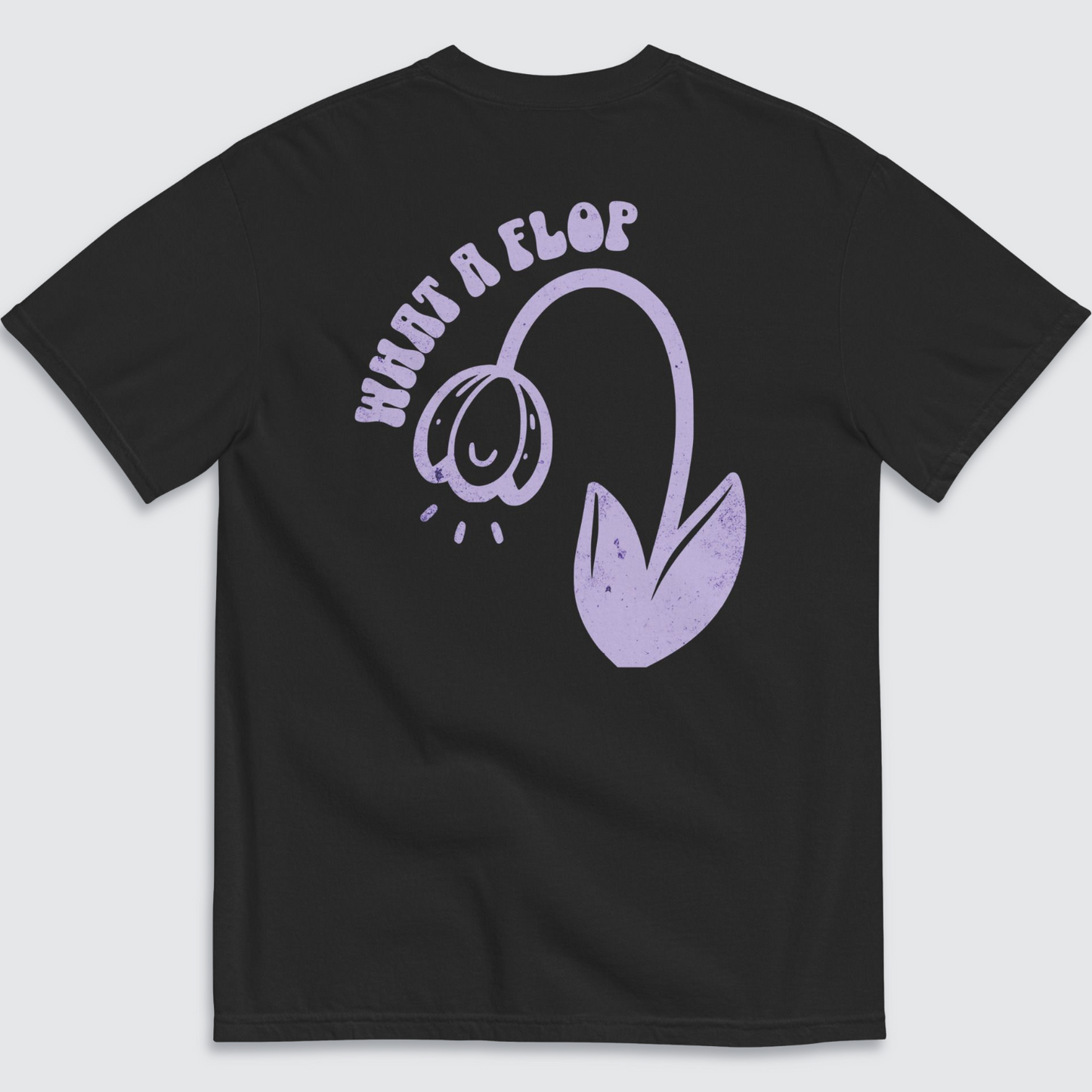 Back of black graphic tshirt with a tulip flopped over and 'what a flop' written above the tulip in a lilac colour palatte