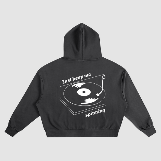 Black hoodie with a vinyl graphic design on the back on a grey background