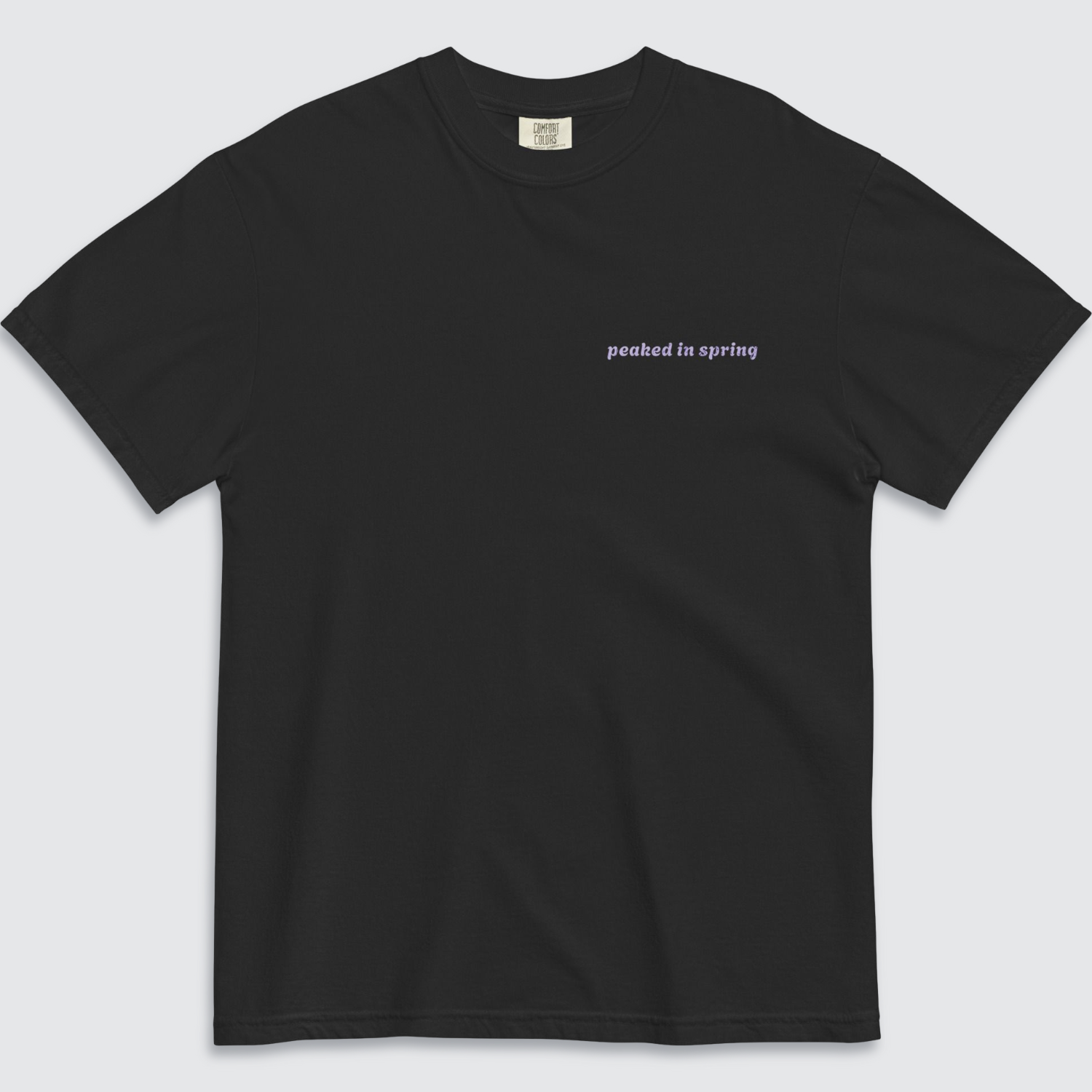 Front of black tshirt with 'peaked in spring' written on the left chest in lilac